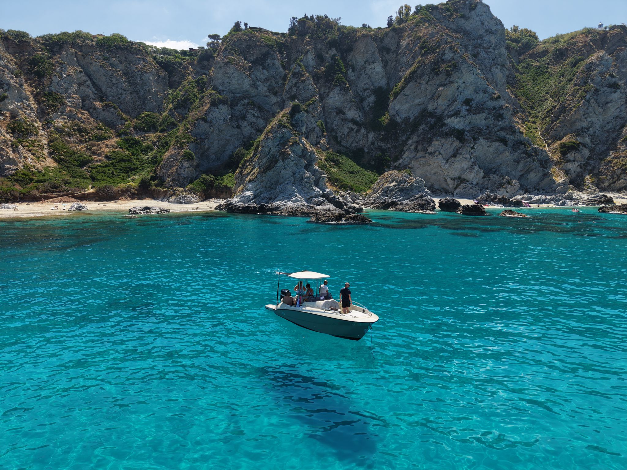 Vista dal drone: la barca Blue Spirits ancorata nell'acqua turchese davanti alle scogliere di Capo Vaticano