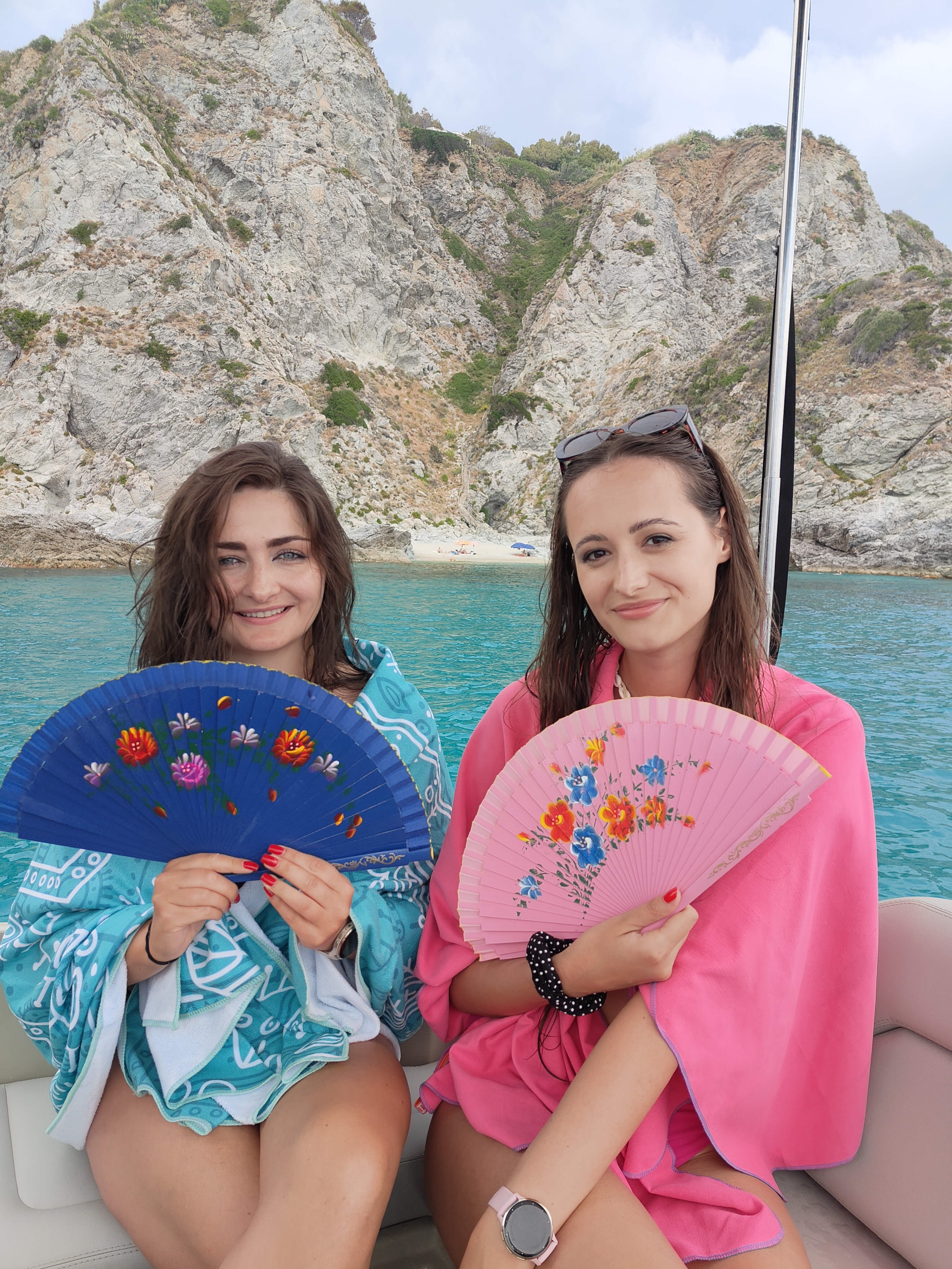 Amiche sorridenti a bordo con i ventagli